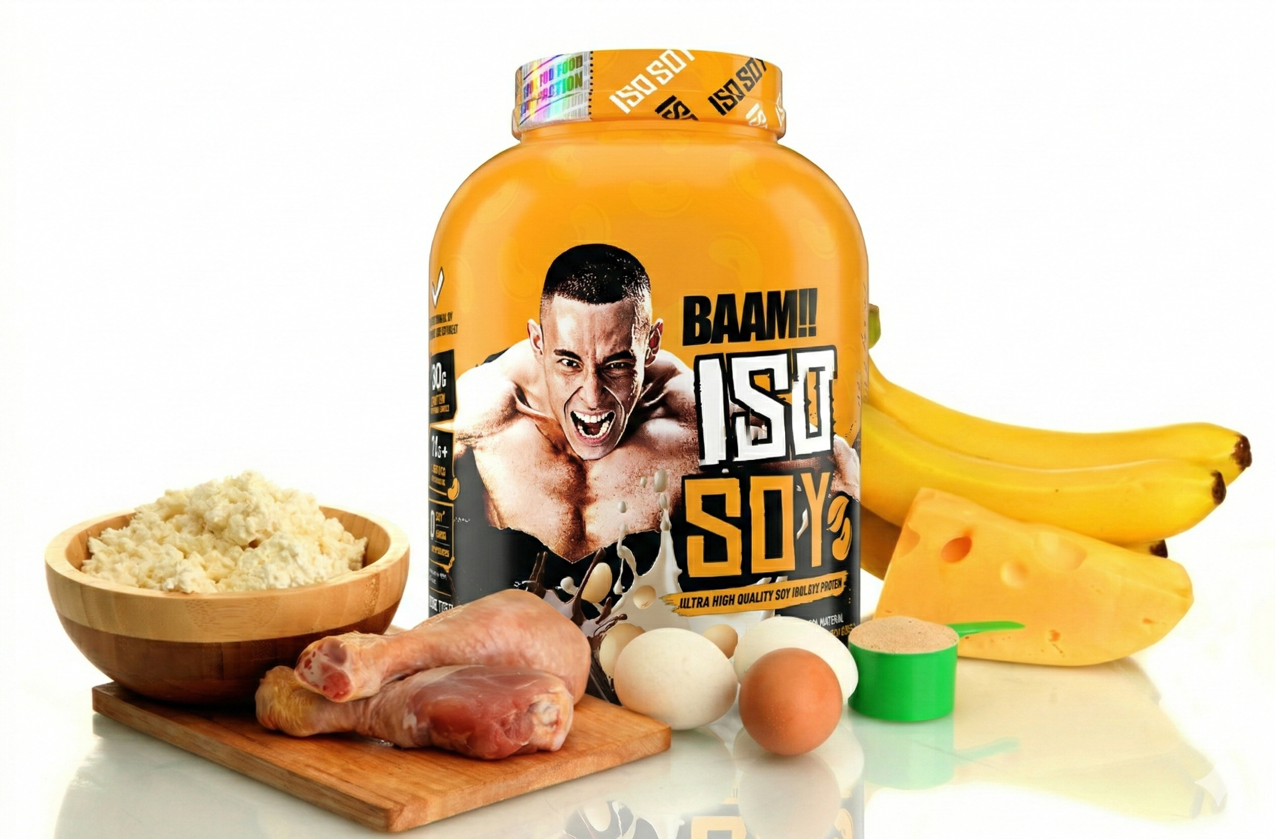 A large yellow tub of "BAAM!! ISO SOY" protein powder is surrounded by various high-protein foods, including raw chicken legs, eggs, a block of Swiss cheese, bananas, a scoop of powder, and a wooden bowl of cottage cheese.